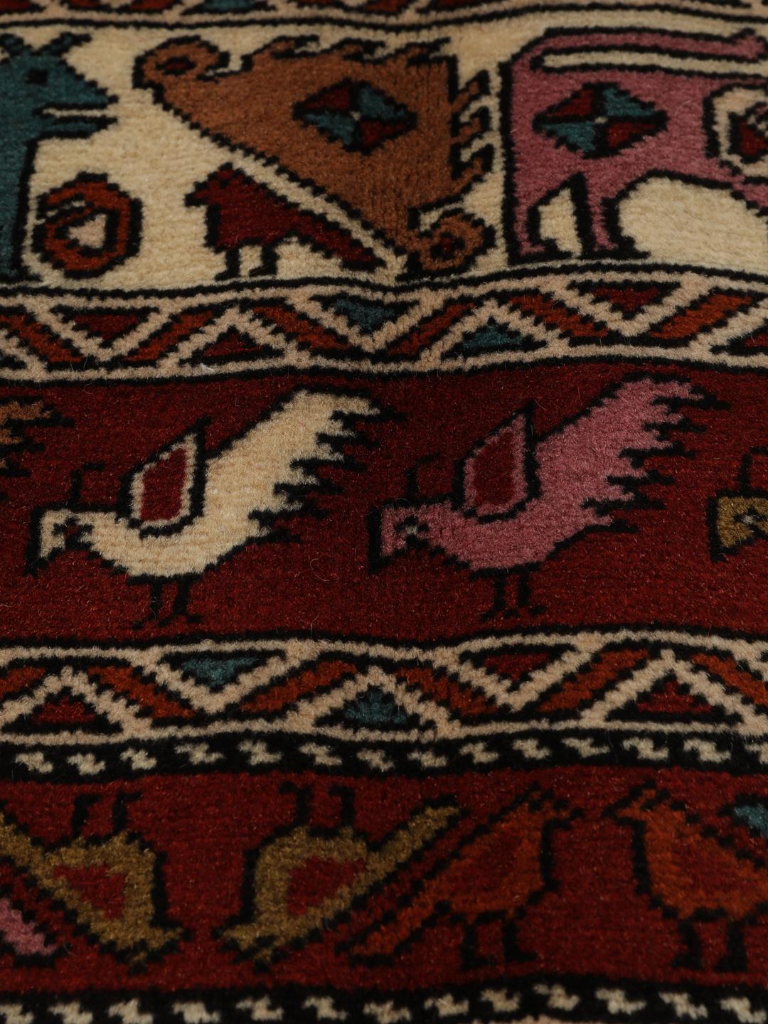 Hand-knotted Middle Eastern rug in red wool with pictorial motifs