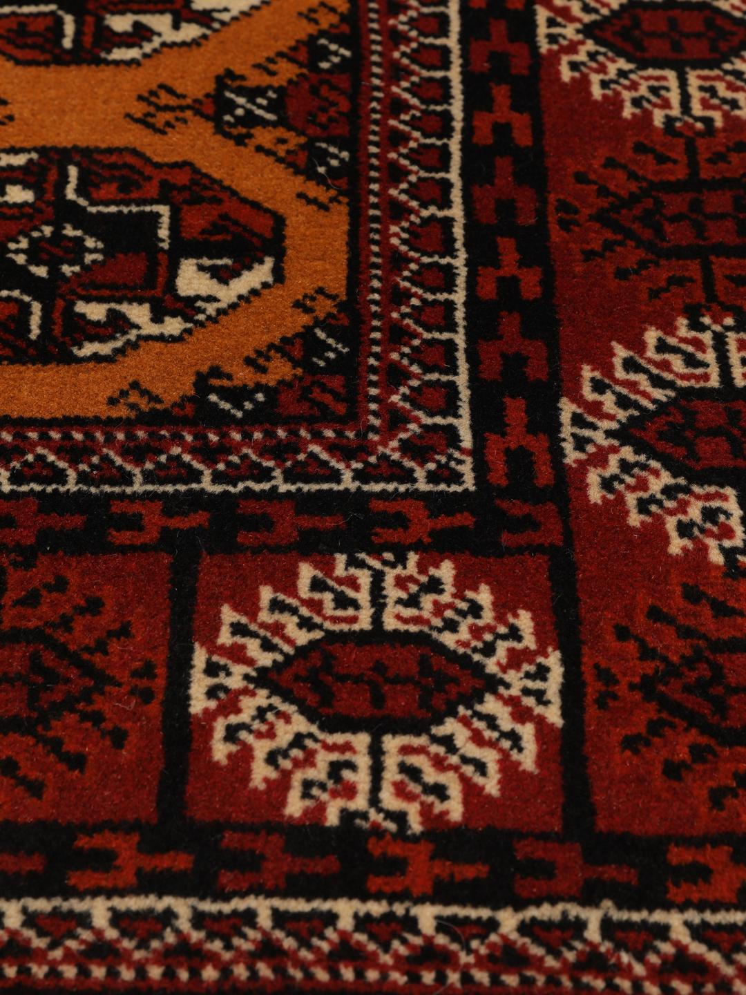 Hand-knotted Turkaman rug from the Middle East featuring an amber field and dark red border.