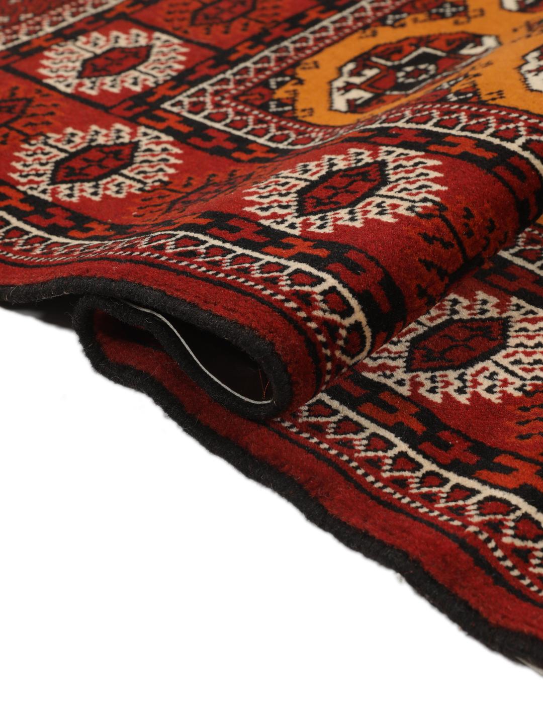 Hand-knotted Turkaman rug from the Middle East featuring an amber field and dark red border.