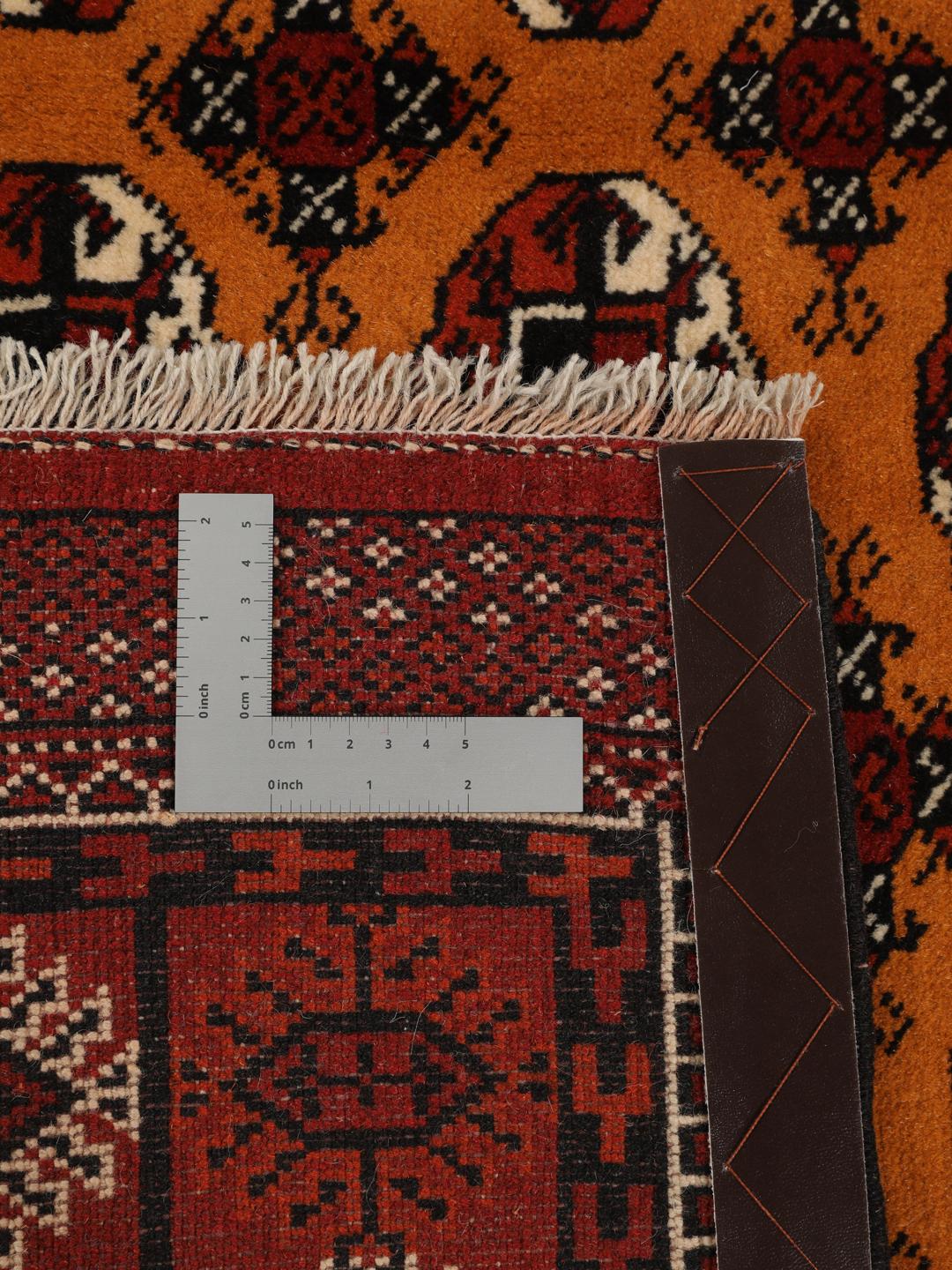Hand-knotted Turkaman rug from the Middle East featuring an amber field and dark red border.