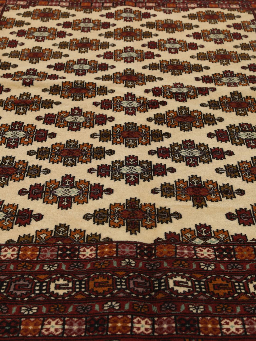 Hand-knotted Turkaman Wool rug from the Middle East in deep red and beige tones