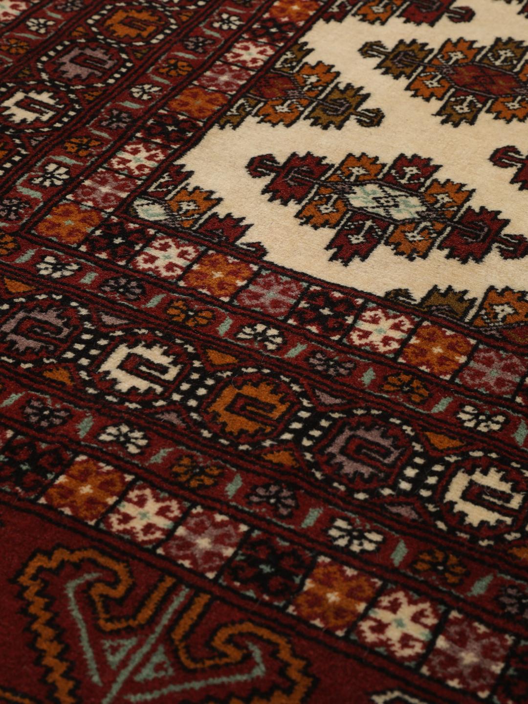 Hand-knotted Turkaman Wool rug from the Middle East in deep red and beige tones