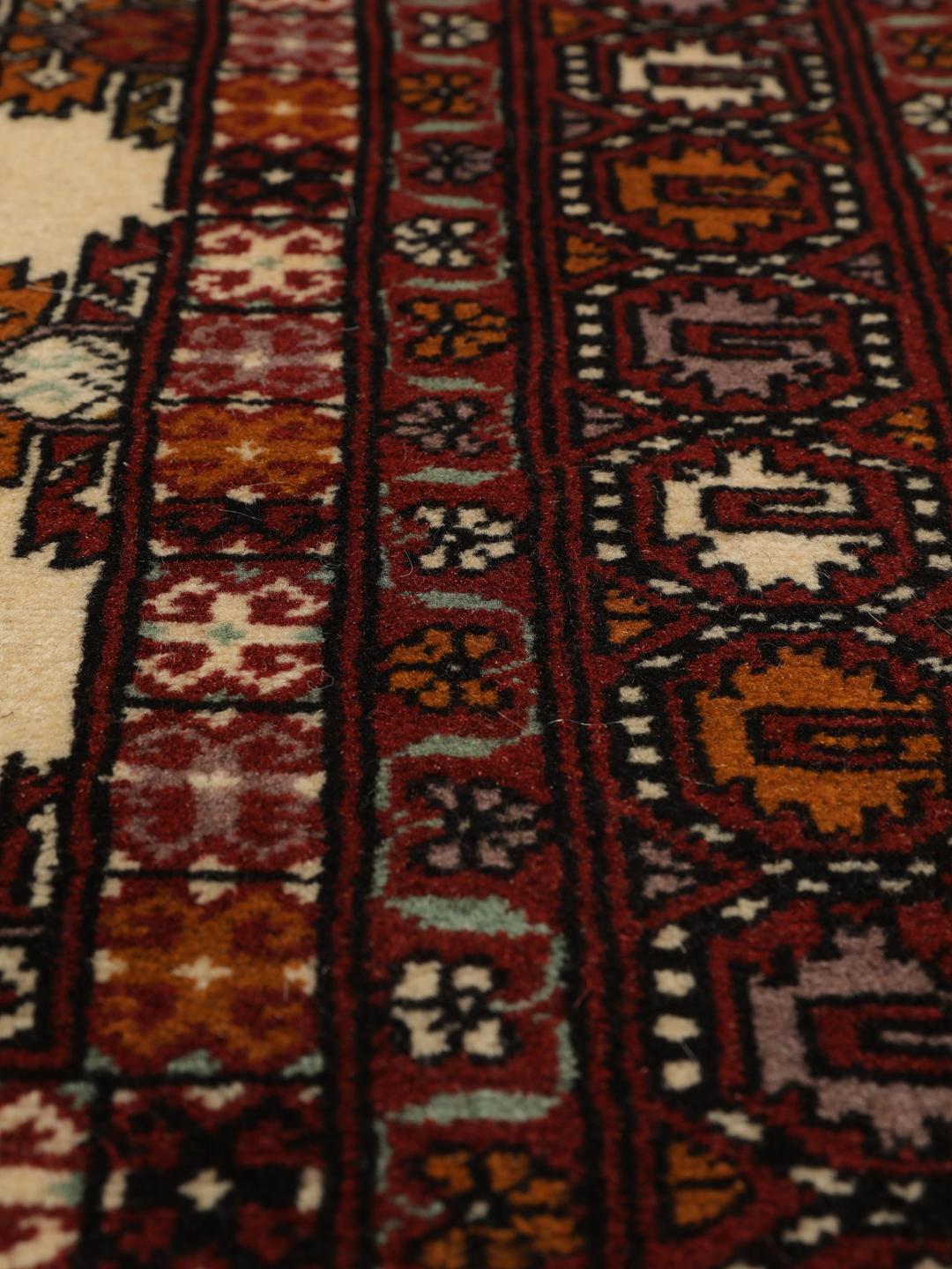 Hand-knotted Turkaman Wool rug from the Middle East in deep red and beige tones