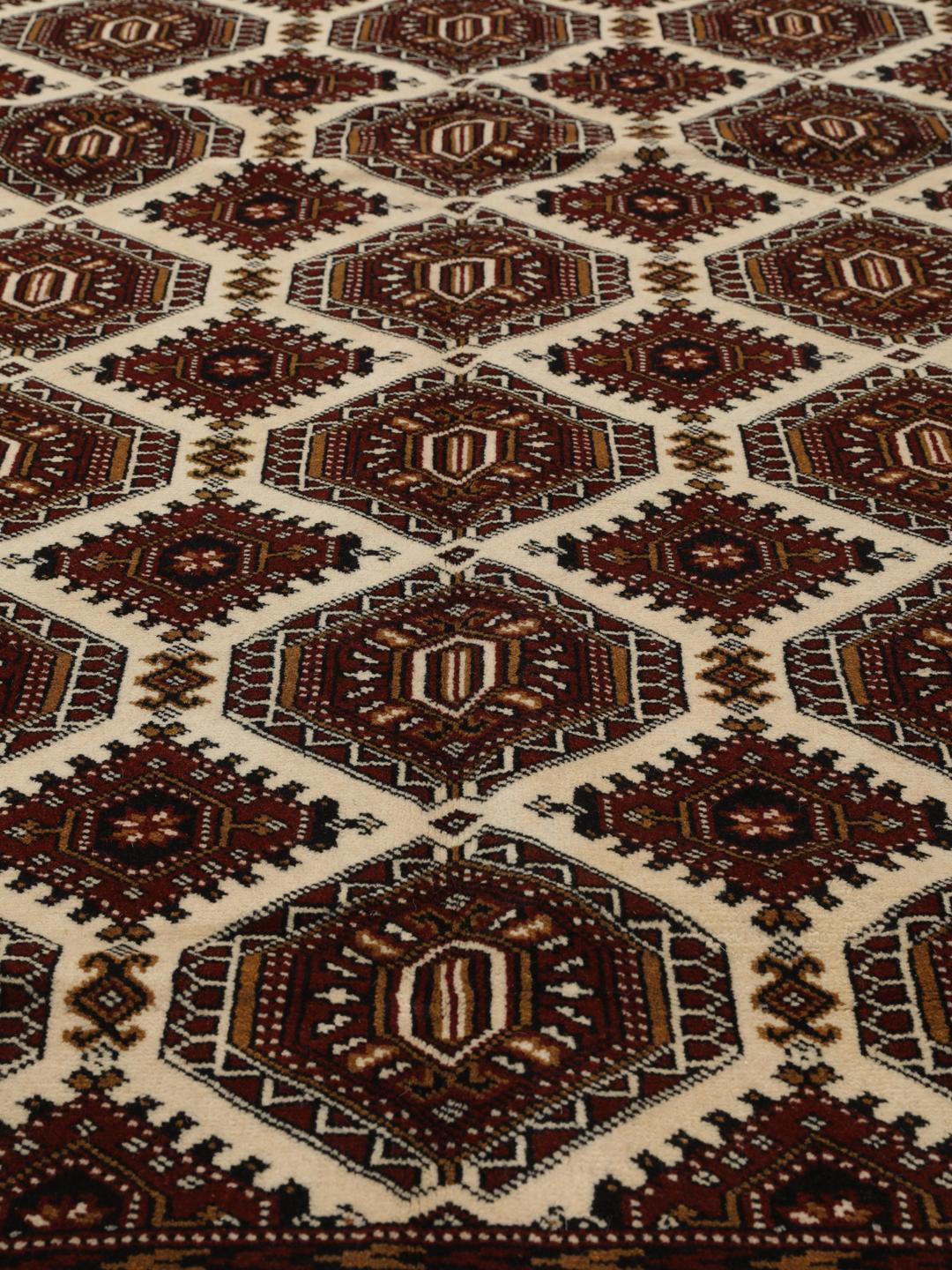 Hand-knotted Turkaman rug from the Middle East in deep red and beige tones