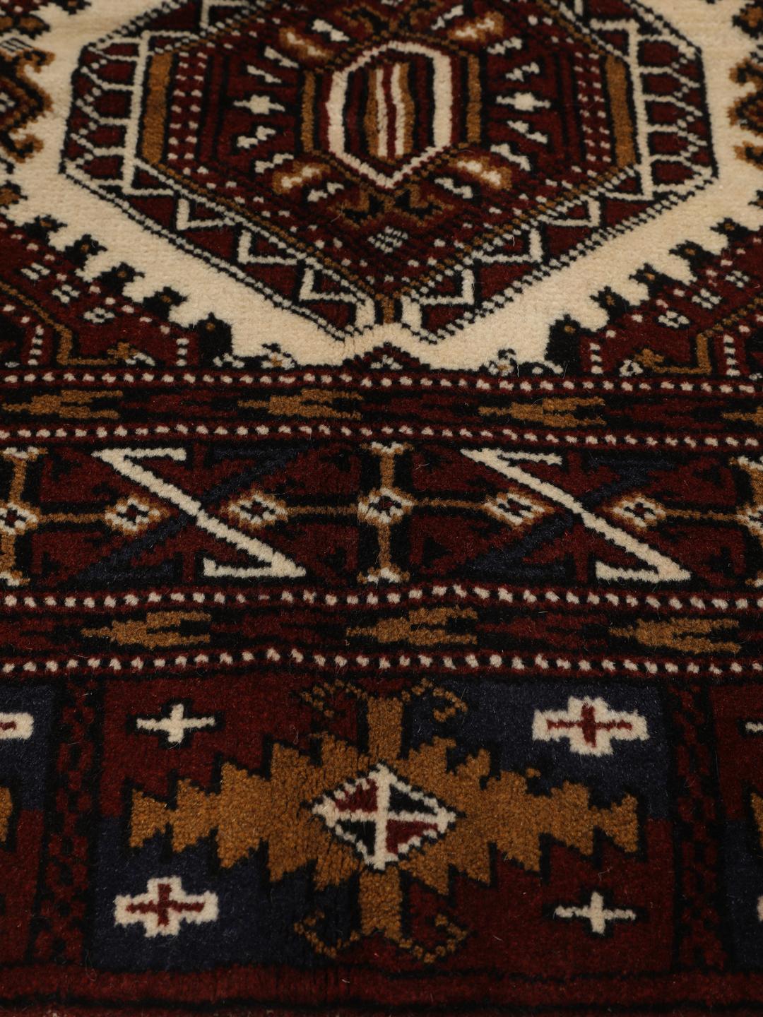 Hand-knotted Turkaman rug from the Middle East in deep red and beige tones