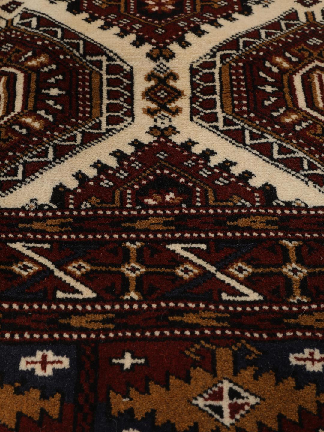 Hand-knotted Turkaman rug from the Middle East in deep red and beige tones