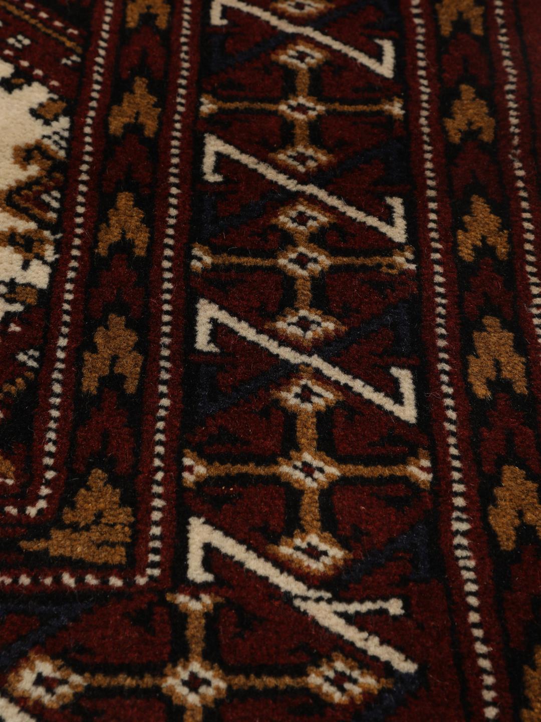 Hand-knotted Turkaman rug from the Middle East in deep red and beige tones