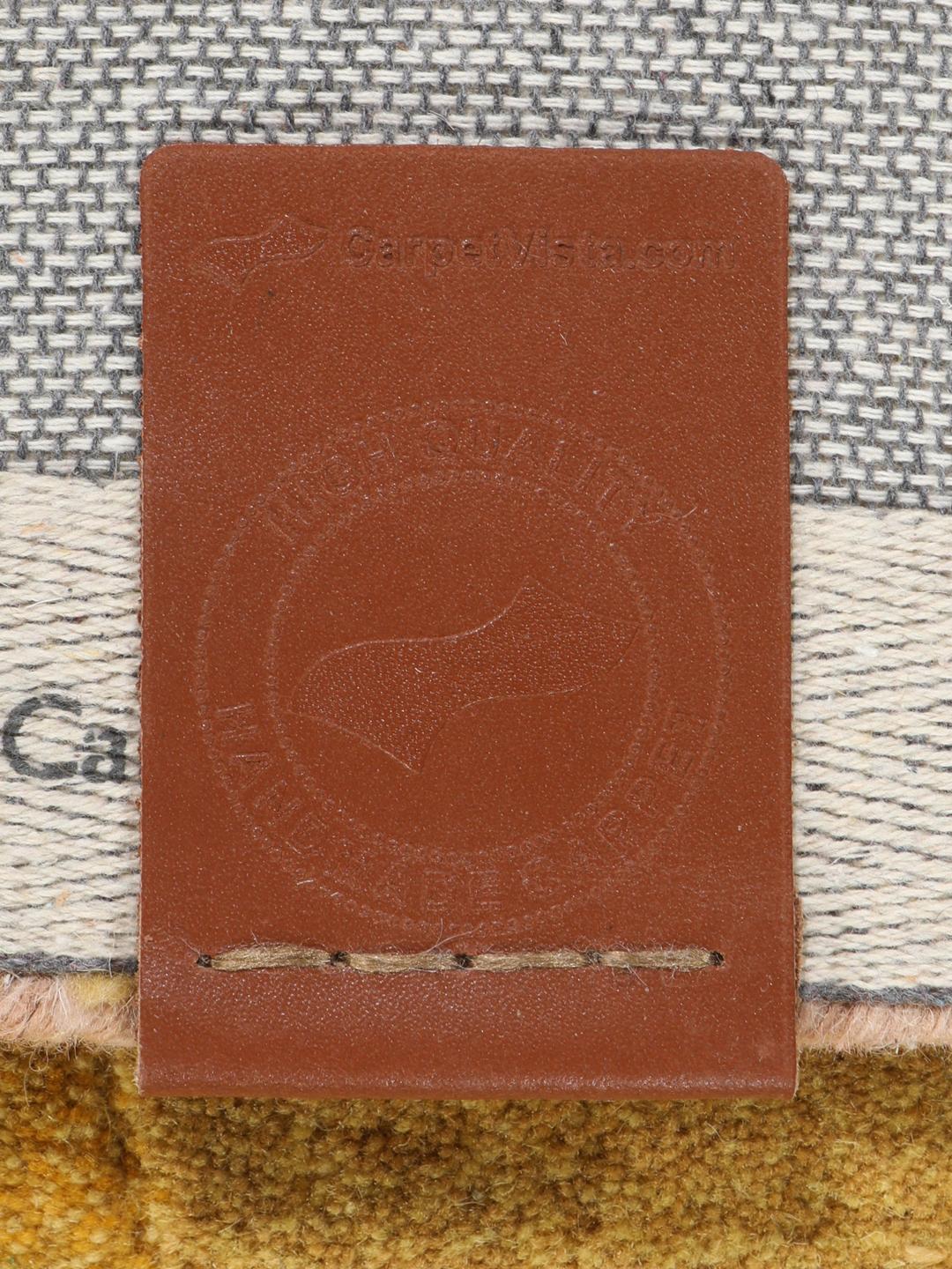 Een rechthoekig handgemaakt wollen tapijt met abstracte peervormen in terracotta en geel.