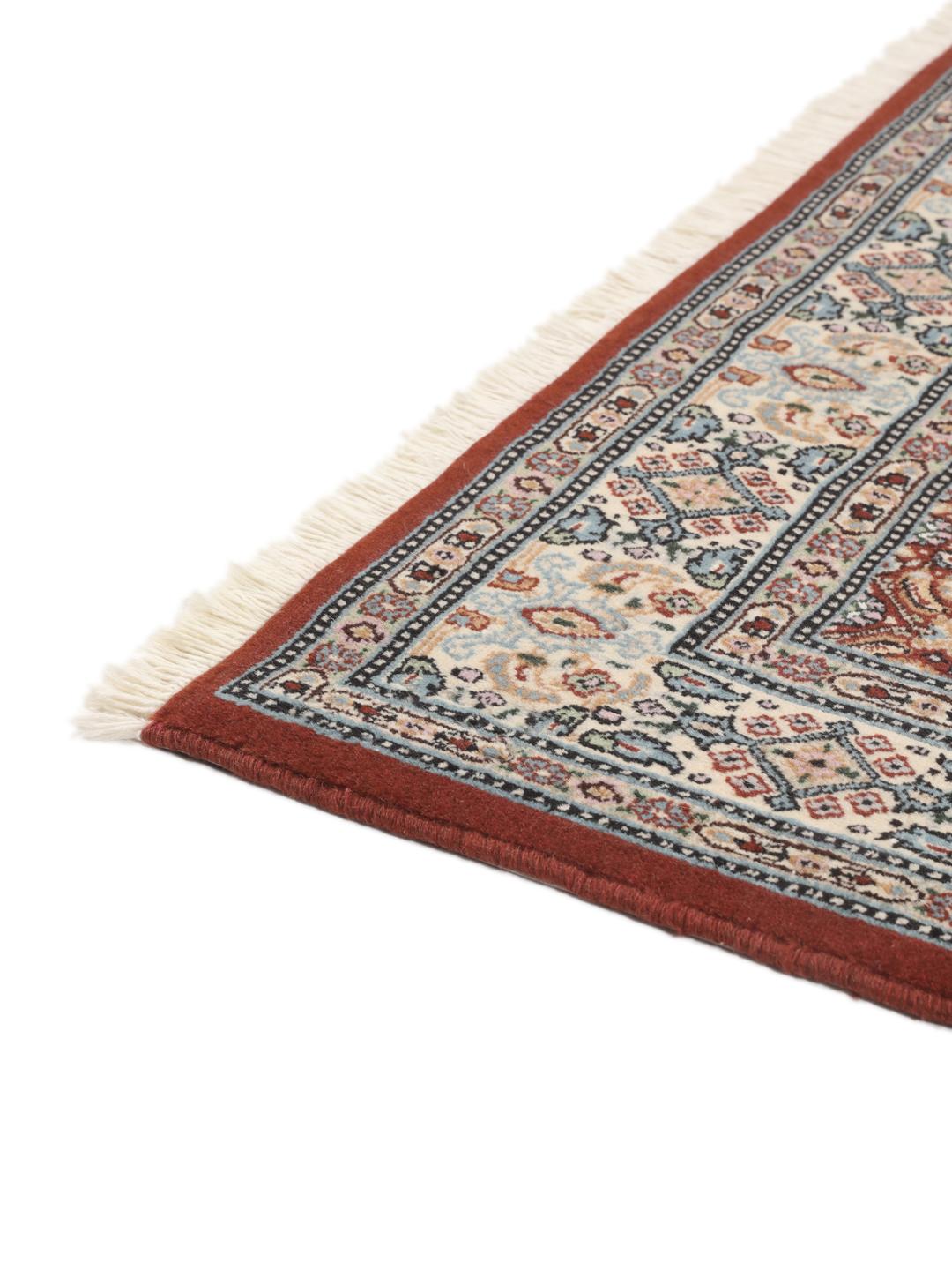 A hand-knotted Moud rug with traditional floral motifs in dark-red and blue tones.