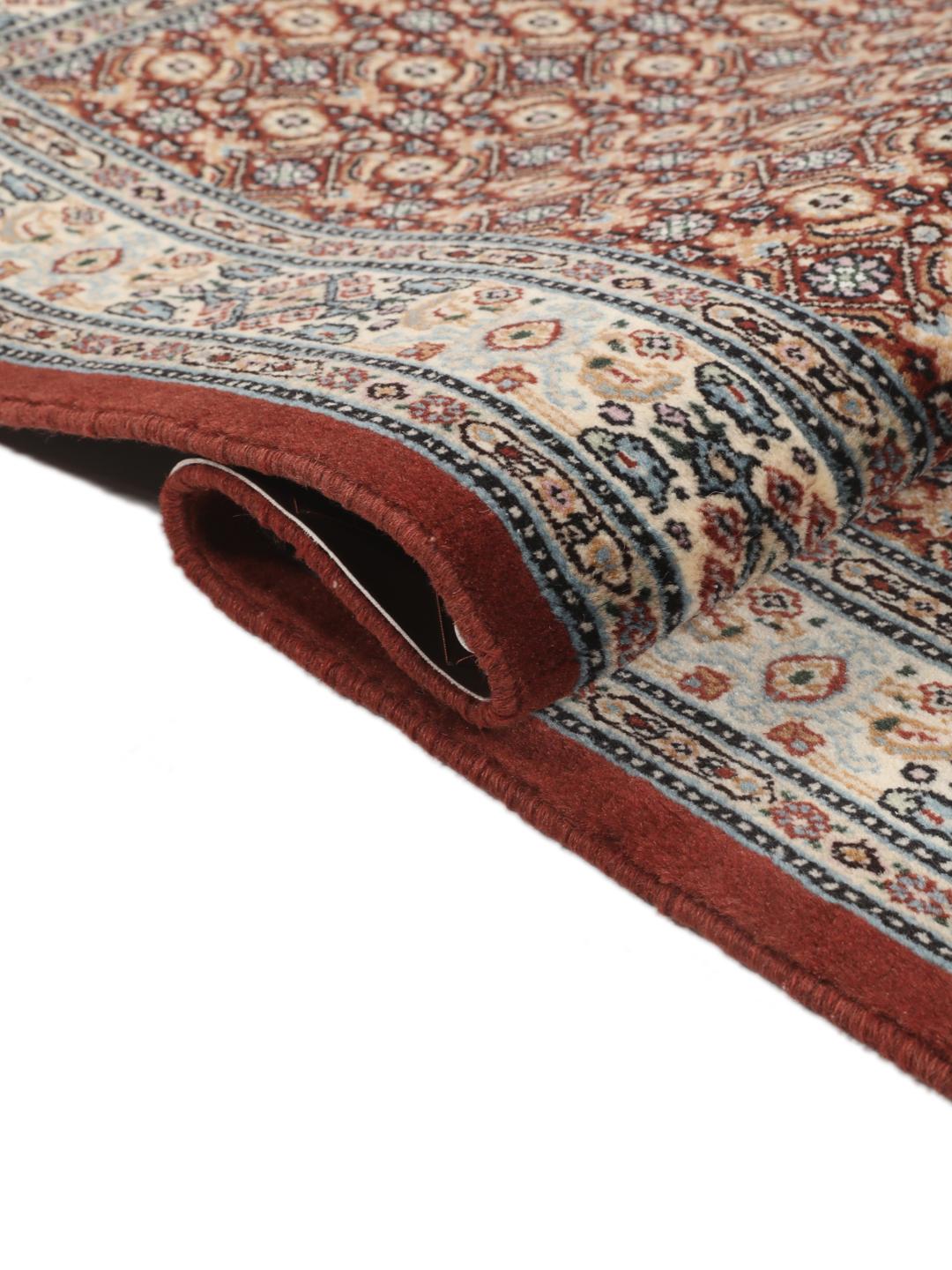 A hand-knotted Moud rug with traditional floral motifs in dark-red and blue tones.