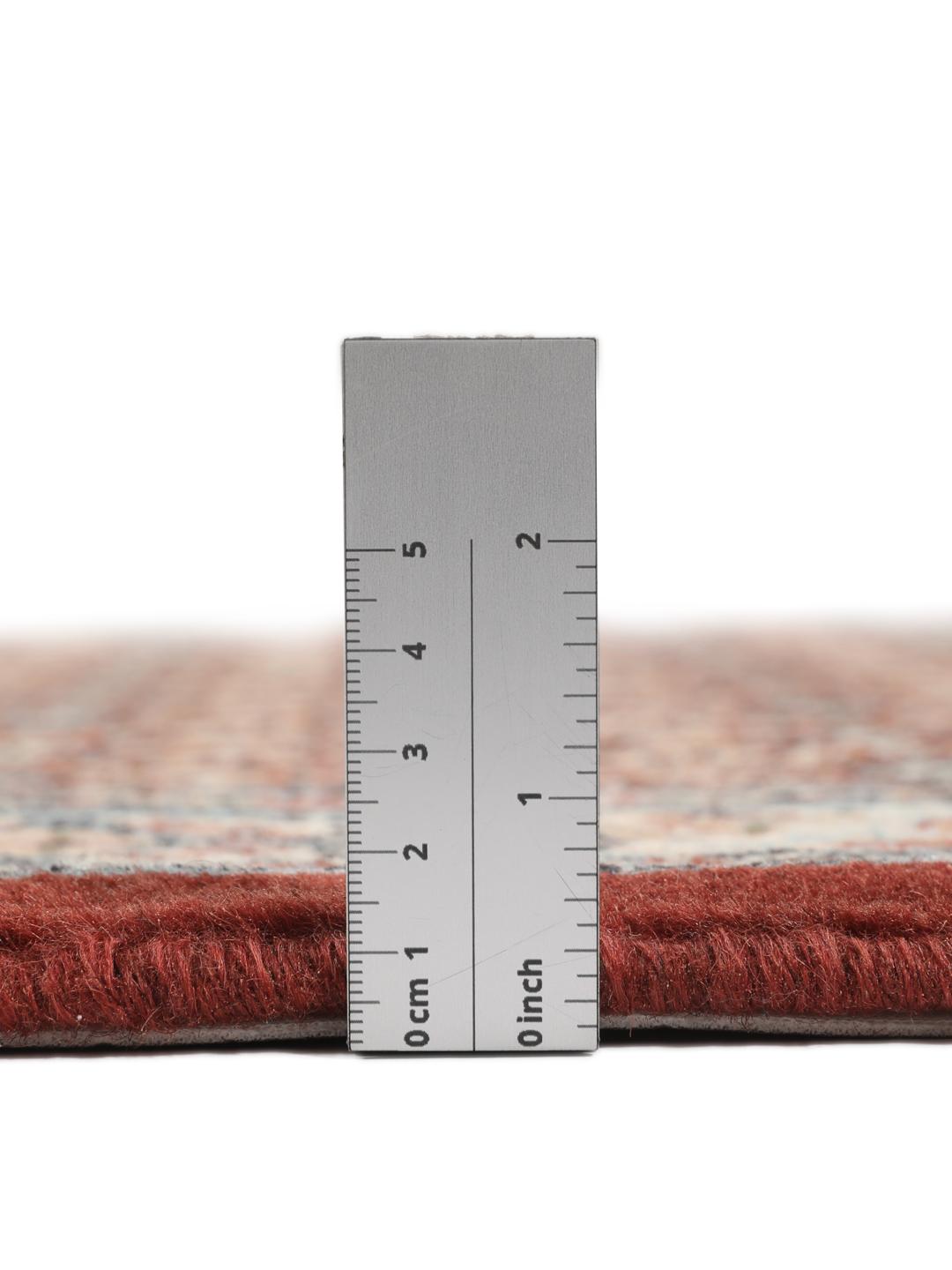 A hand-knotted Moud rug with traditional floral motifs in dark-red and blue tones.