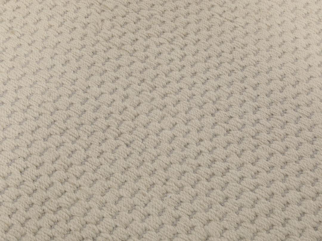 Een minimalistisch handgeweven vloerkleed uit India in een zachte beige tint.