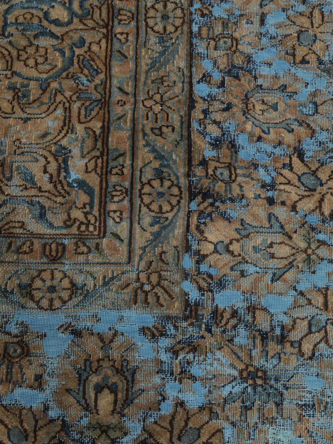 Een groot rechthoekig vintage kleed uit het Midden-Oosten met een bloemendesign in blauwe en bruine tinten.