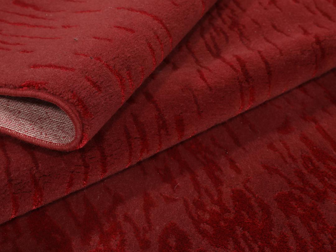 Een luxueus rood vloerkleed met subtiele patronen, perfect voor moderne interieurs.