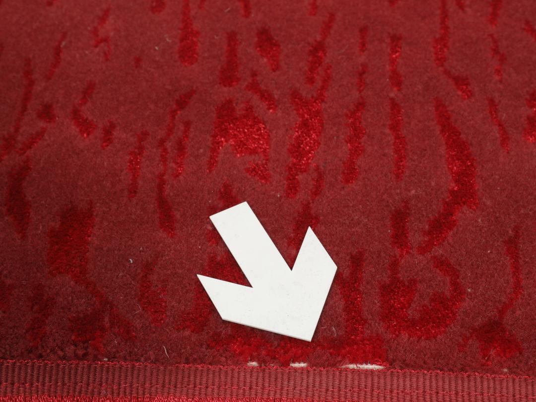 Een luxueus rood vloerkleed met subtiele patronen, perfect voor moderne interieurs.