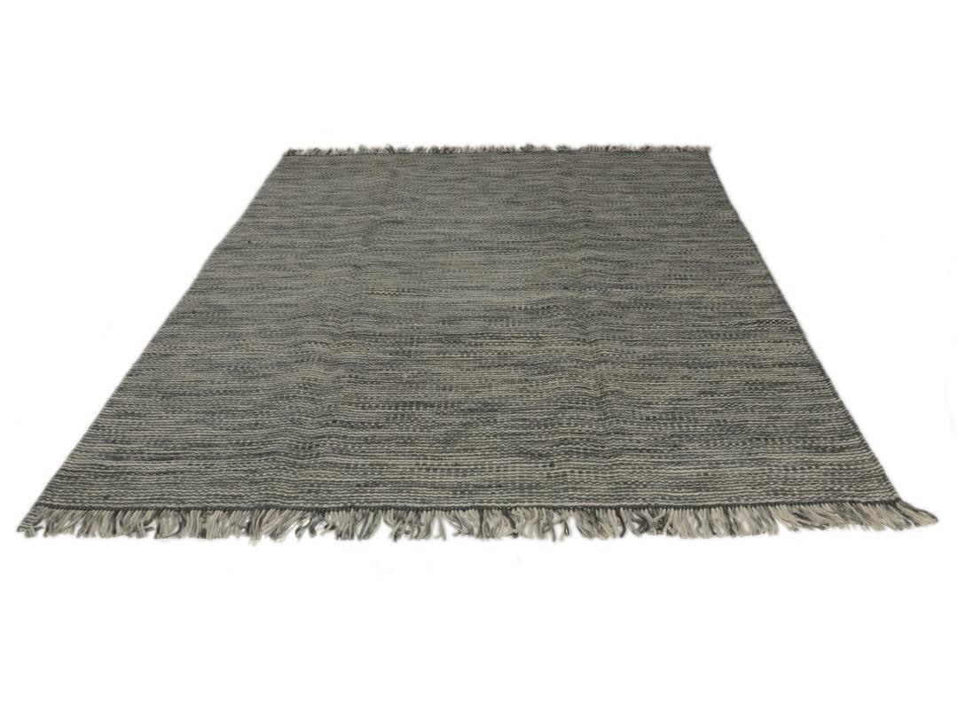 Handgeweven Indiaas tapijt in grijstinten met een getextureerde, minimalistische uitstraling.