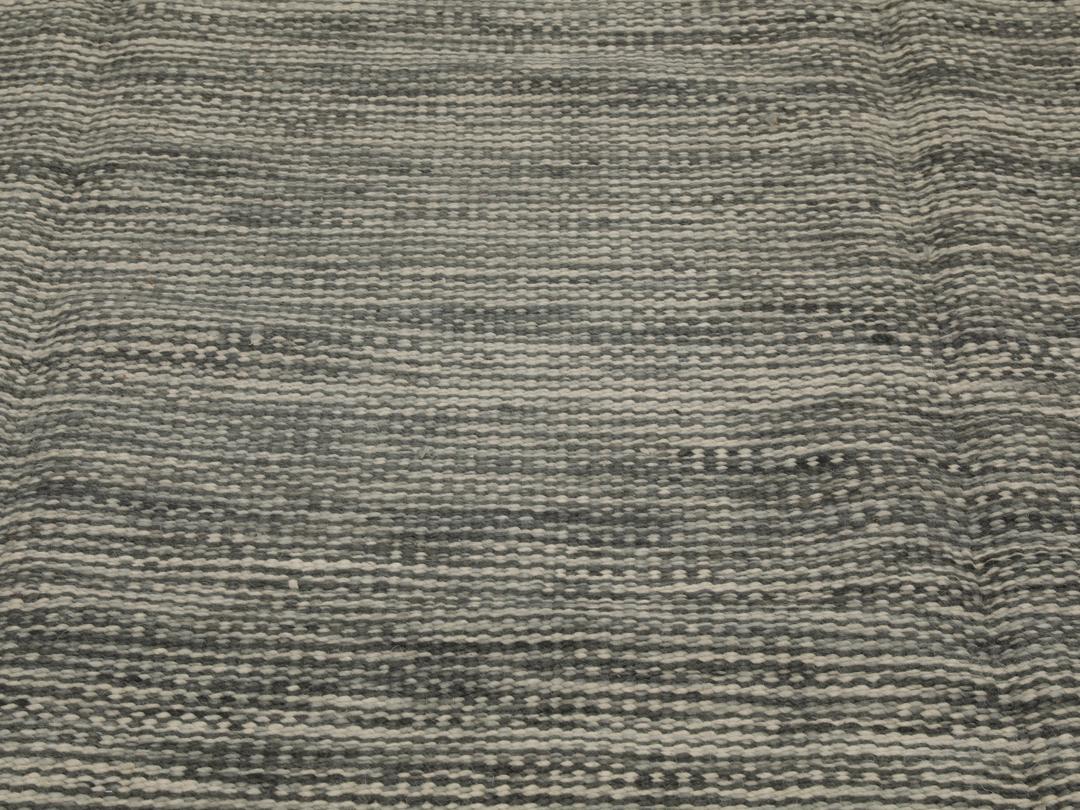Handgeweven Indiaas tapijt in grijstinten met een getextureerde, minimalistische uitstraling.