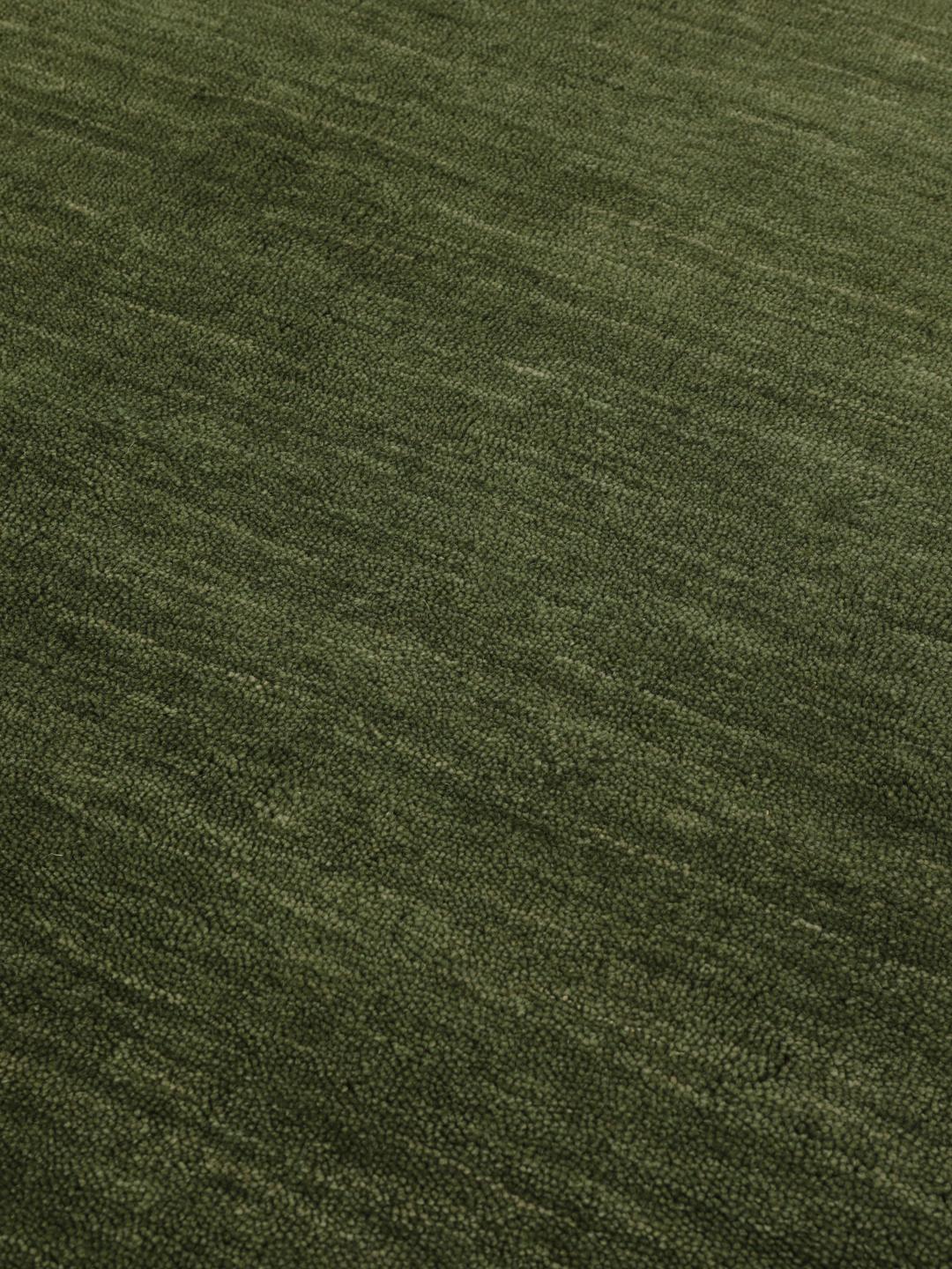 Pyöreä vihreä matto yksinkertaisella ja yhtenäisellä muotoilulla
