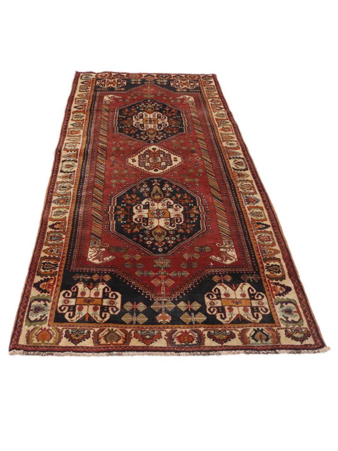 A hand-knotted, one-of-a-kind Qashqai runner rug with a deep red field and intricate geometric medallions.