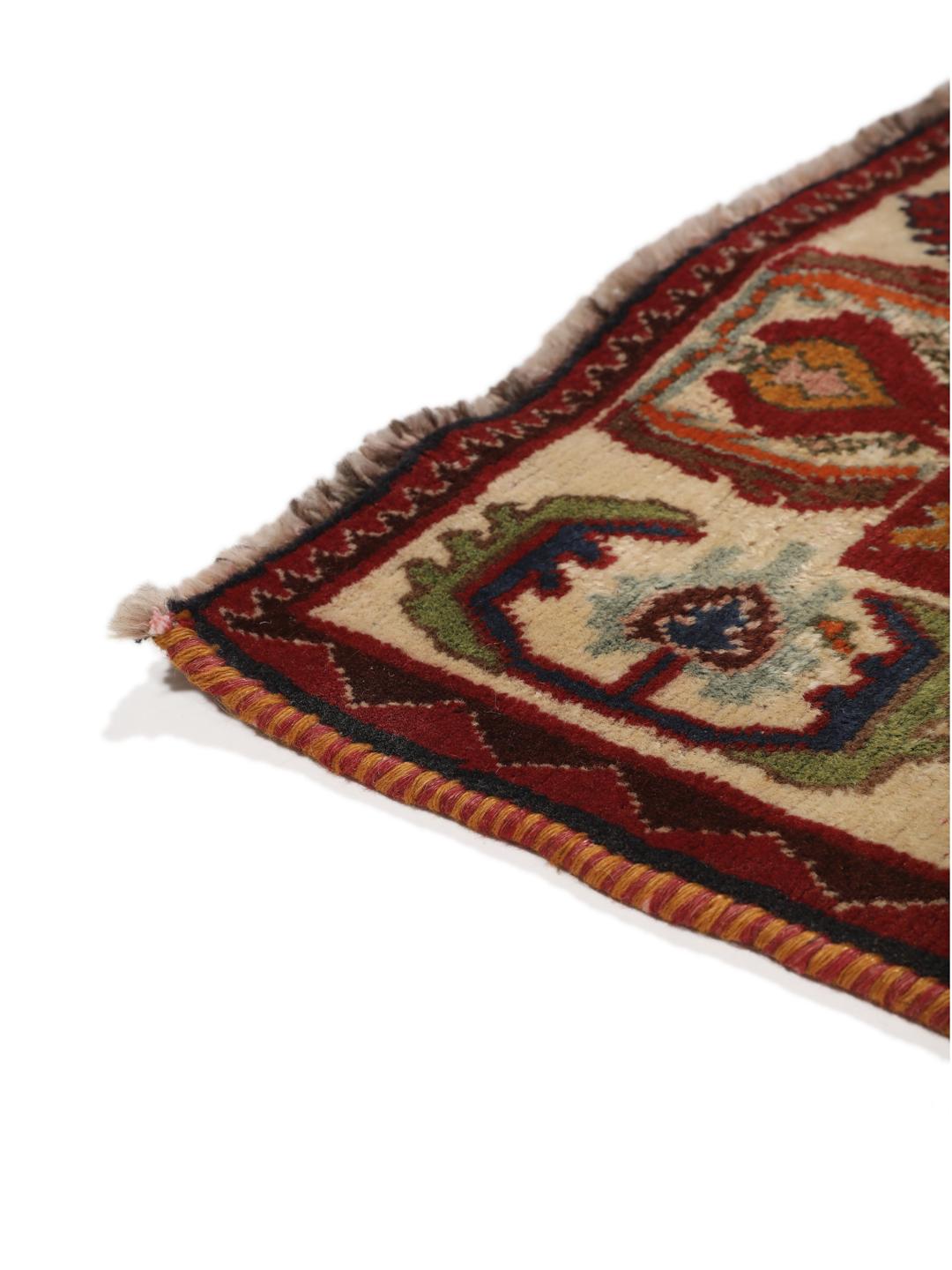 A hand-knotted, one-of-a-kind Qashqai runner rug with a deep red field and intricate geometric medallions.