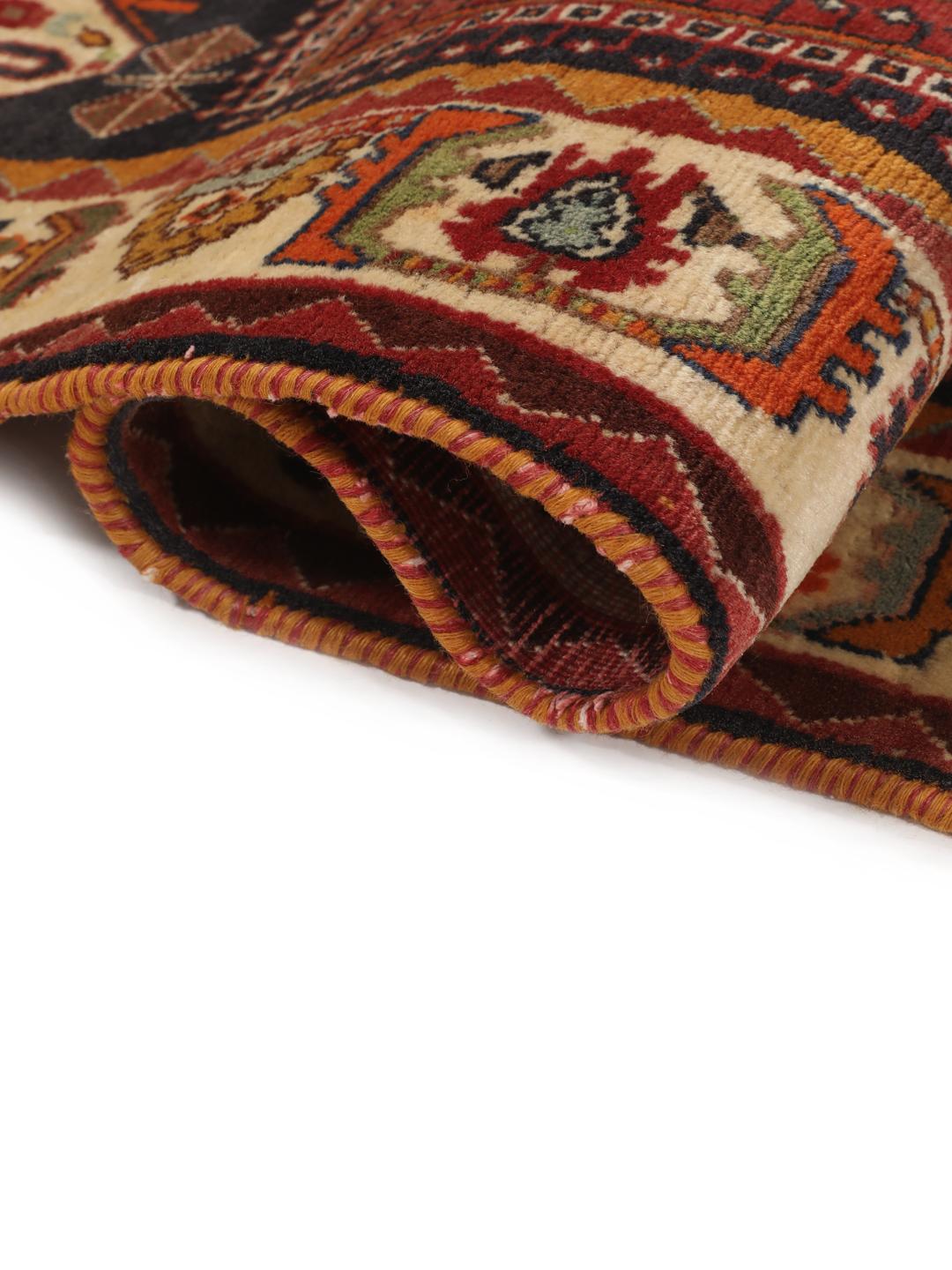 A hand-knotted, one-of-a-kind Qashqai runner rug with a deep red field and intricate geometric medallions.