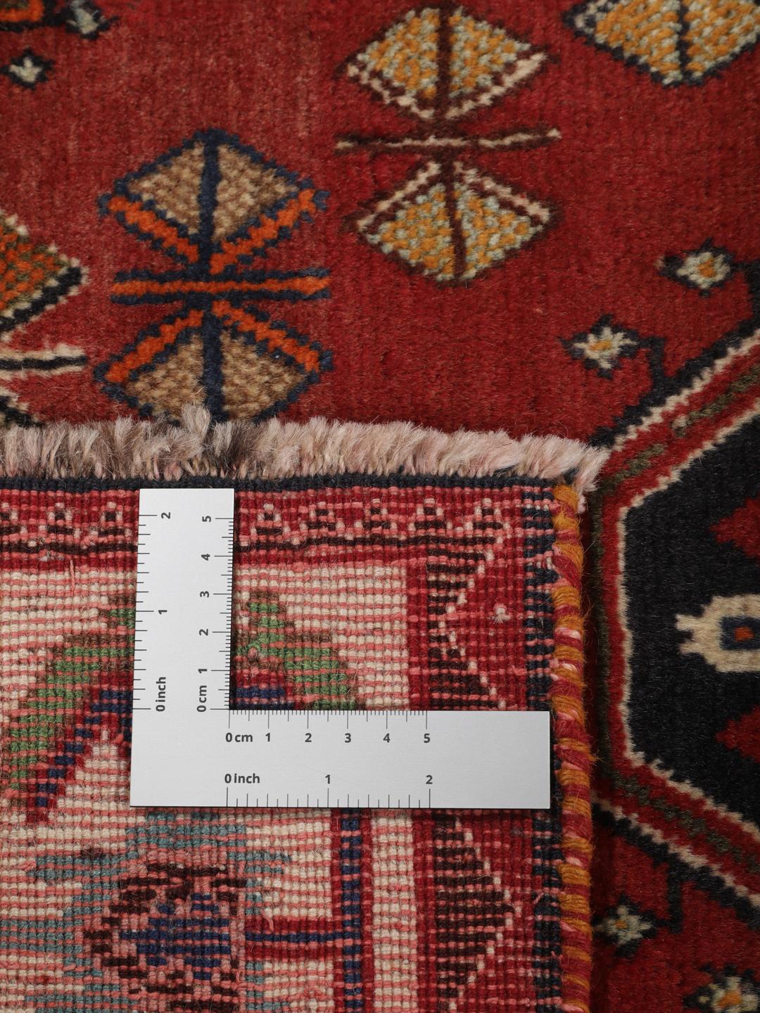 A hand-knotted, one-of-a-kind Qashqai runner rug with a deep red field and intricate geometric medallions.