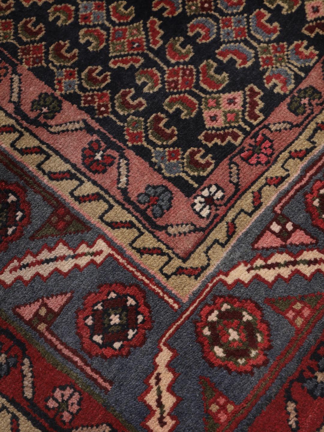 Een handgeknoopt Koliai tapijt uit het Midden-Oosten in rode en blauwe tinten.