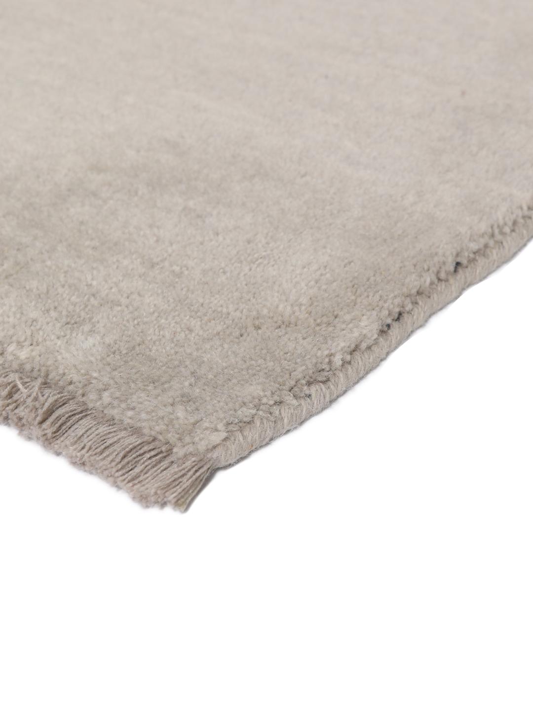Een minimalistisch beige handgeweven tapijt uit India met een zachte, monochrome pool.