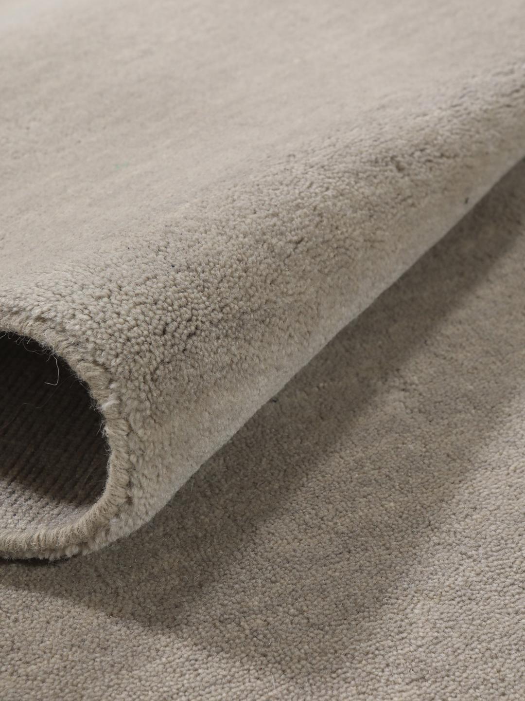 Een minimalistisch beige handgeweven tapijt uit India met een zachte, monochrome pool.