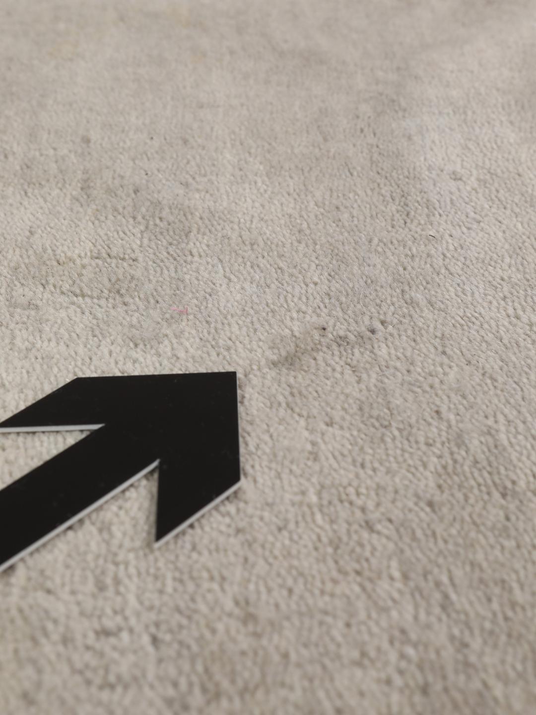 Een minimalistisch beige handgeweven tapijt uit India met een zachte, monochrome pool.