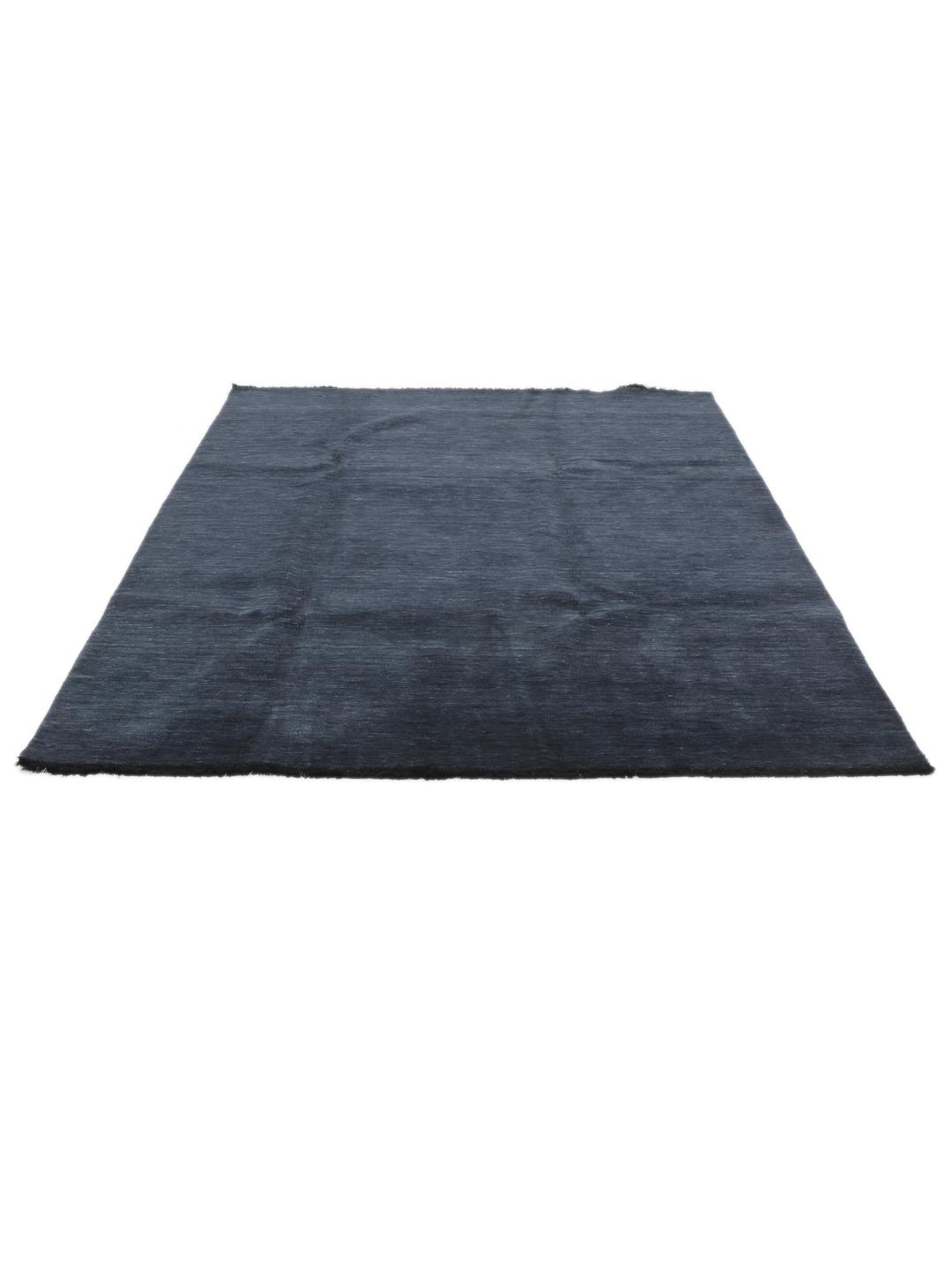 Een effen donkerblauw handgeweven tapijt met een zachte, dichte pool.