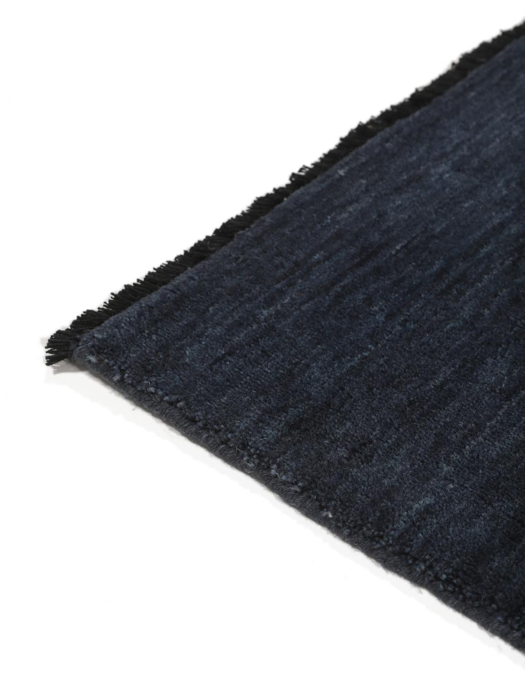 Een effen donkerblauw handgeweven tapijt met een zachte, dichte pool.