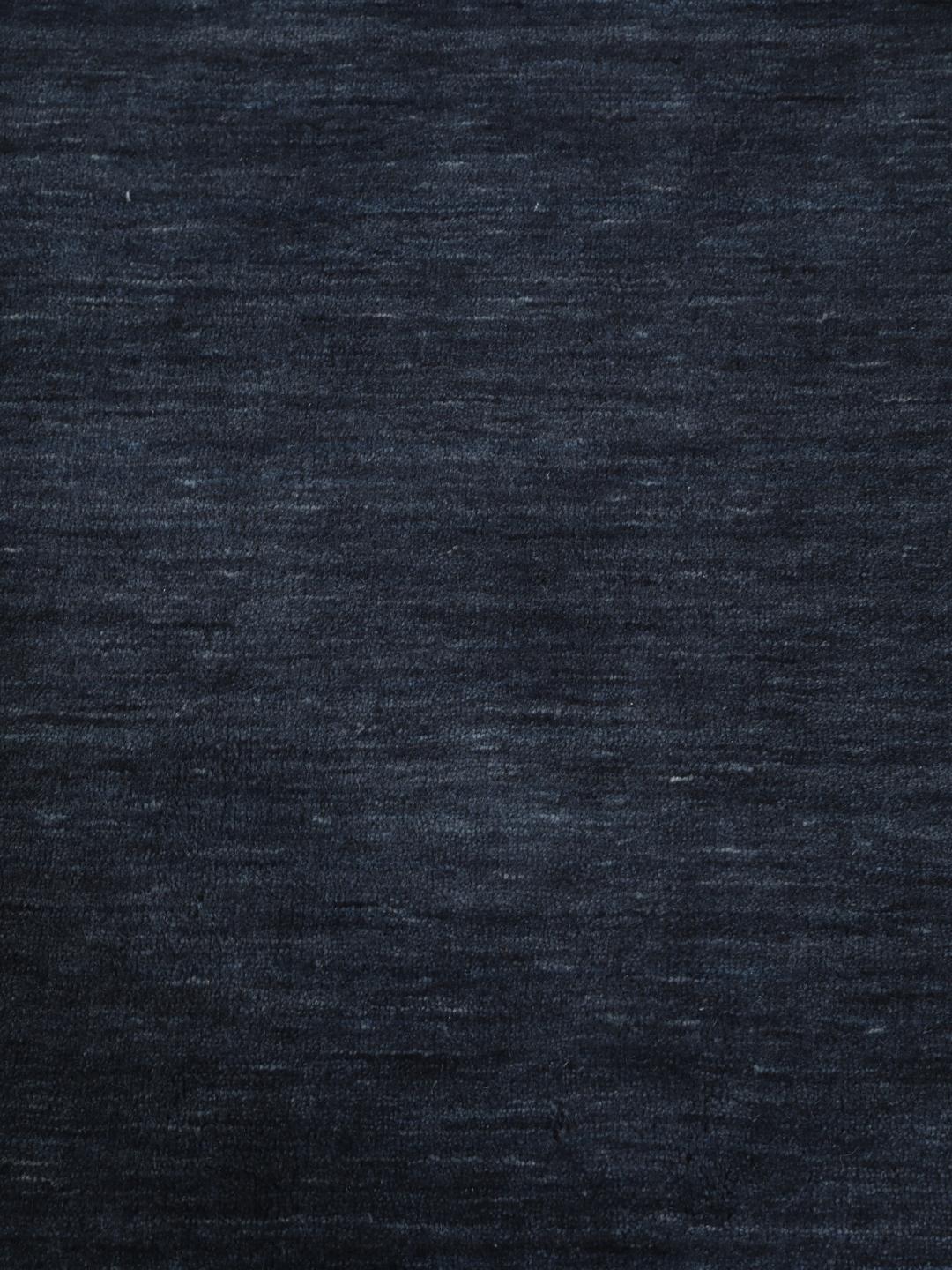 Een effen donkerblauw handgeweven tapijt met een zachte, dichte pool.