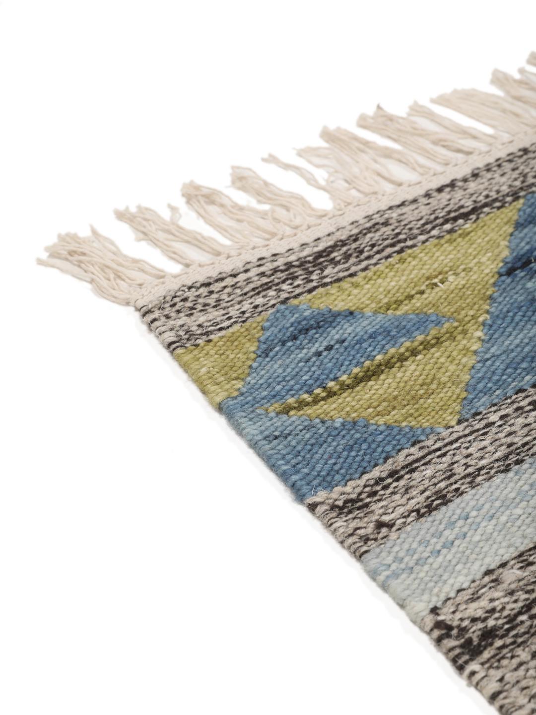 Tapete kilim indiano tecido à mão com padrões de diamante vibrantes sobre um fundo cinzento