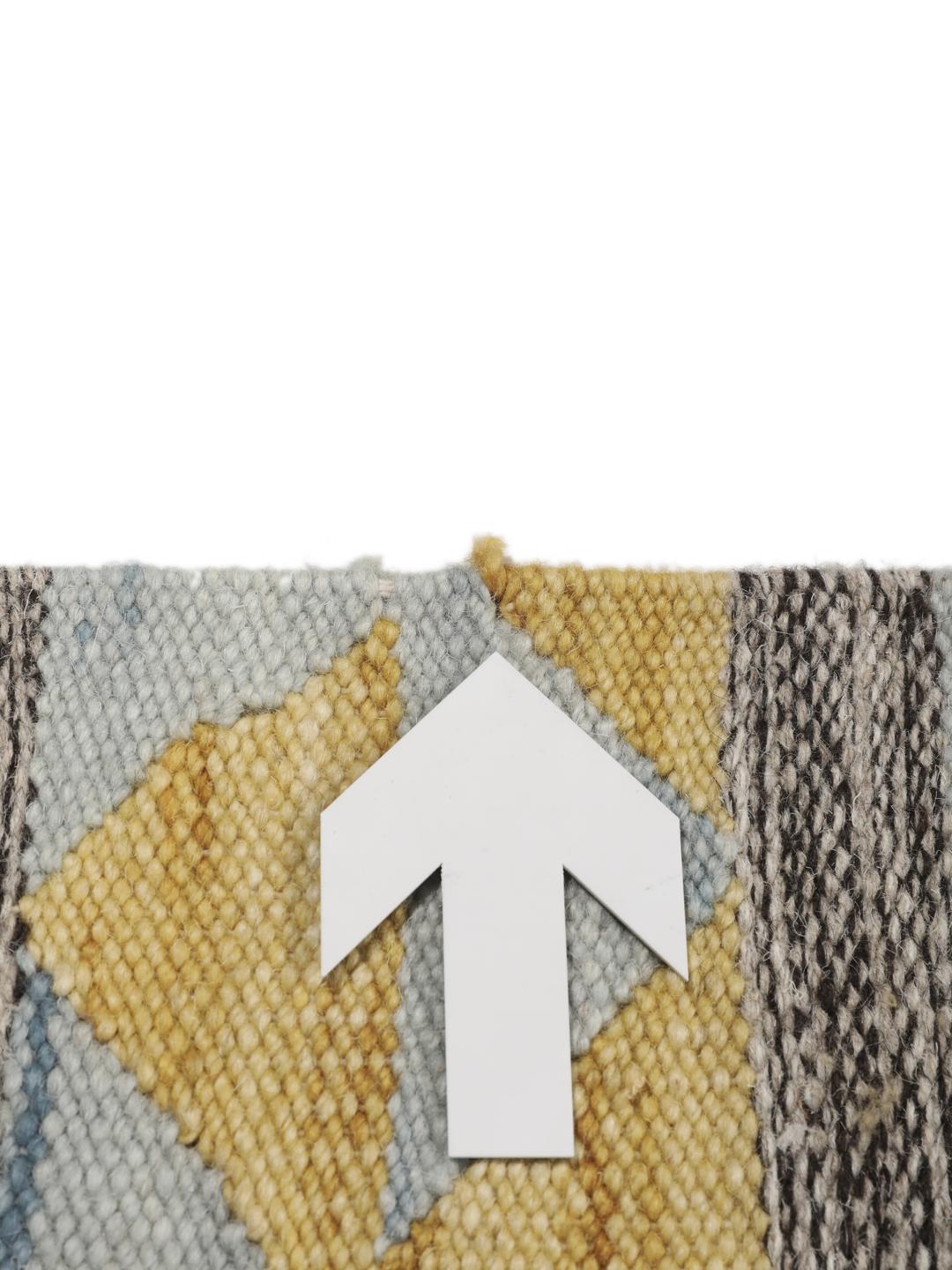 Tapete kilim indiano tecido à mão com padrões de diamante vibrantes sobre um fundo cinzento
