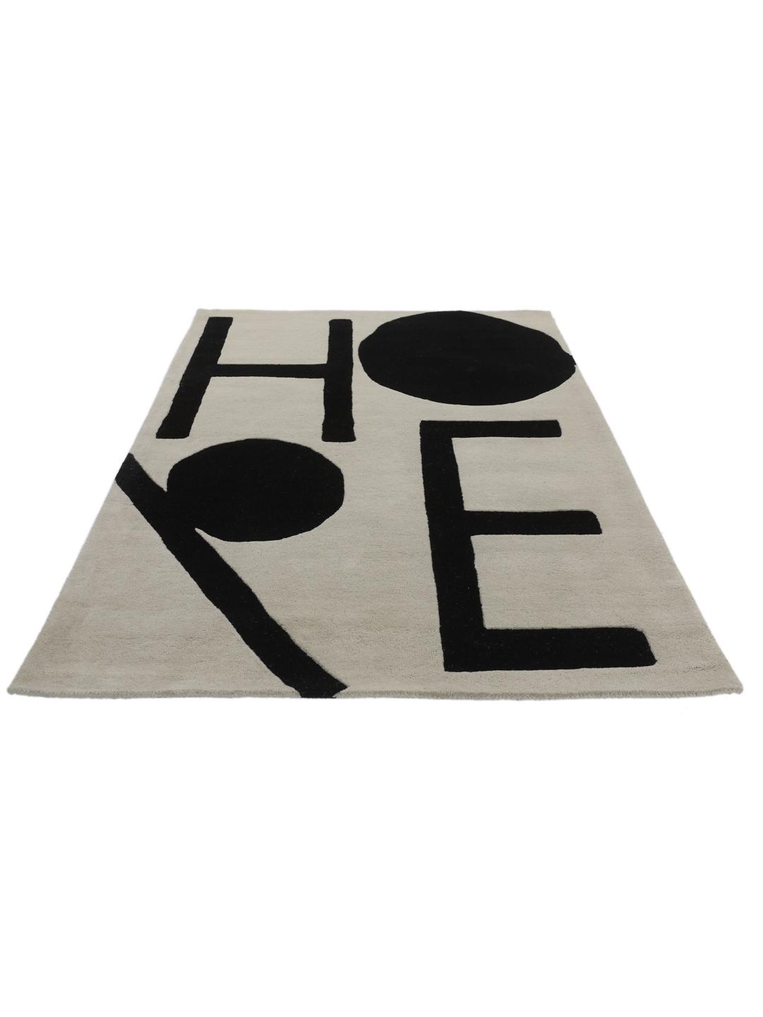 Et rektangulært tæppe med ordet Future i stor sort typografi på en off-white baggrund.