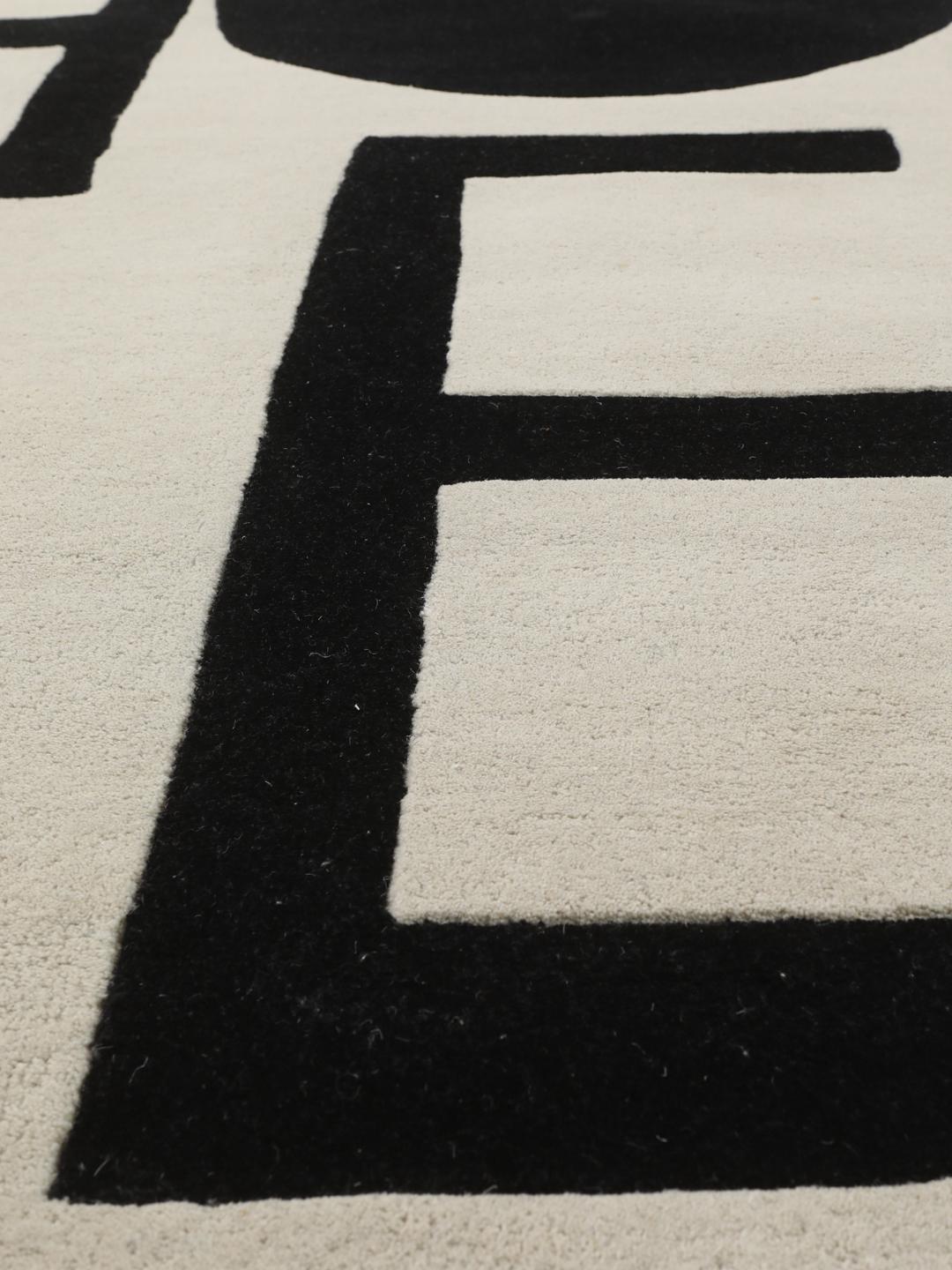 Een rechthoekig tapijt met het woord Future in grote zwarte typografie op een off-white achtergrond.