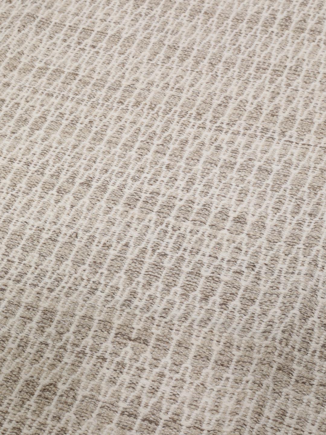 Håndvevd Kilim-teppe fra India i en myk beige tone med intrikate langstingsdetaljer.