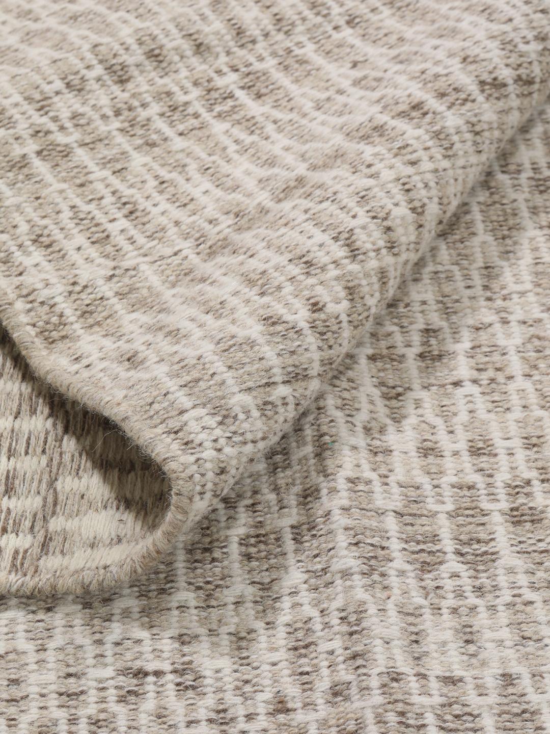 Håndvevd Kilim-teppe fra India i en myk beige tone med intrikate langstingsdetaljer.