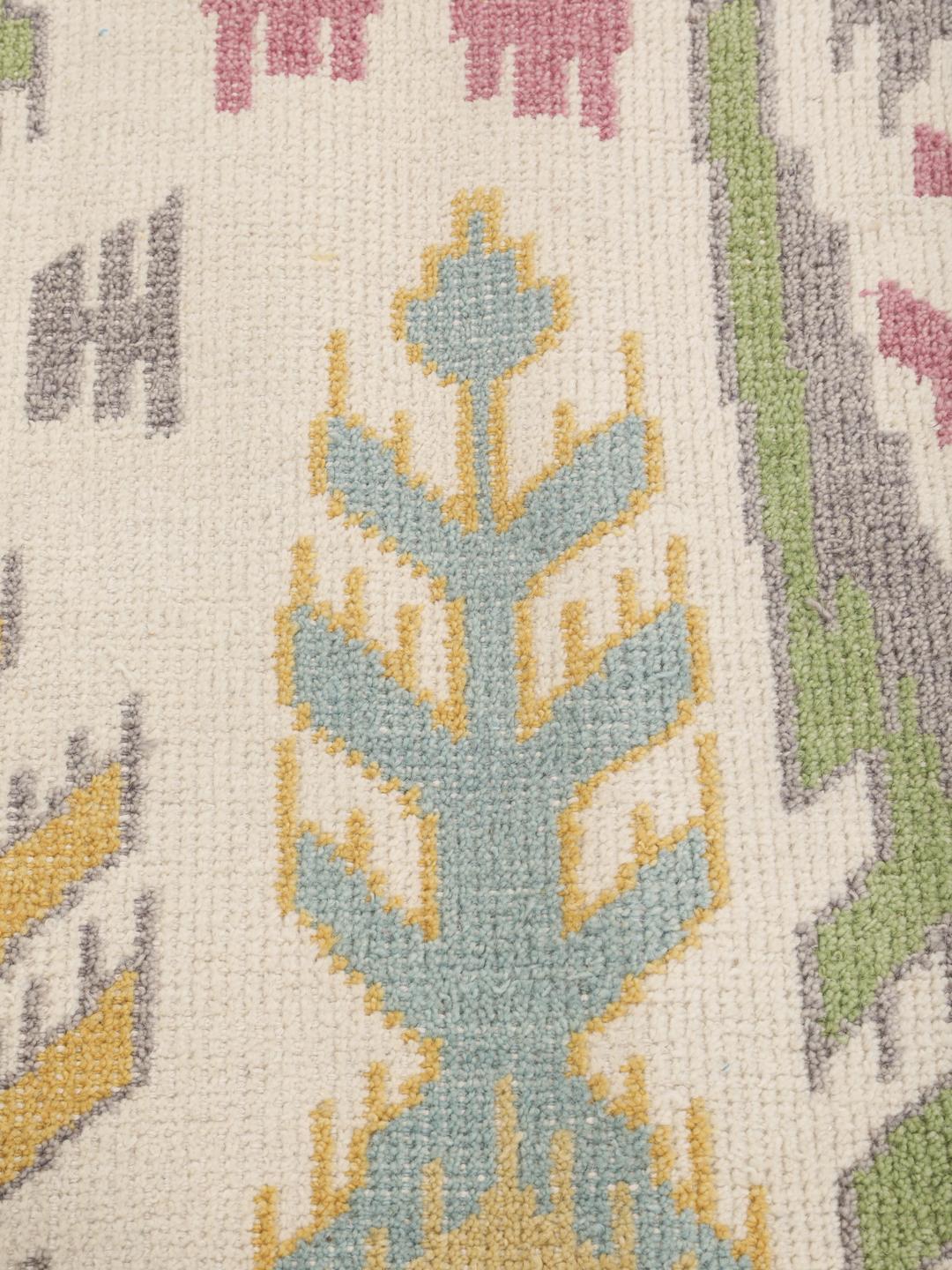 Een levendig rechthoekig tapijt met een op ikat geïnspireerd patroon in meerkleurige tinten.
