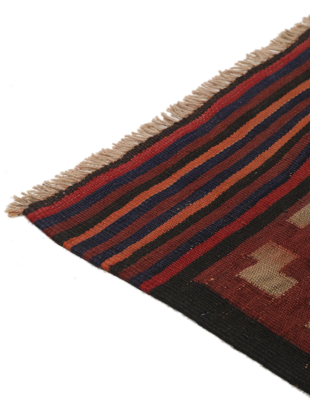 Tapis Kilim vintage afghan avec des motifs géométriques en losange dans des tons rouges et sombres.