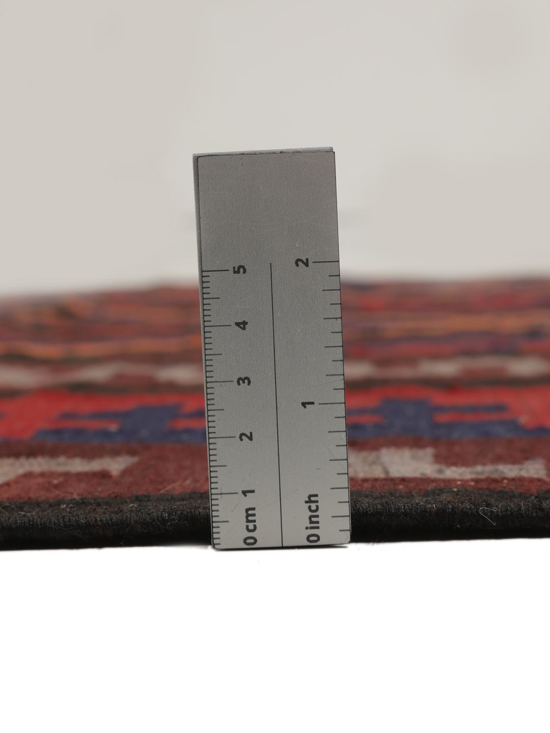 Tapis Kilim vintage afghan avec des motifs géométriques en losange dans des tons rouges et sombres.