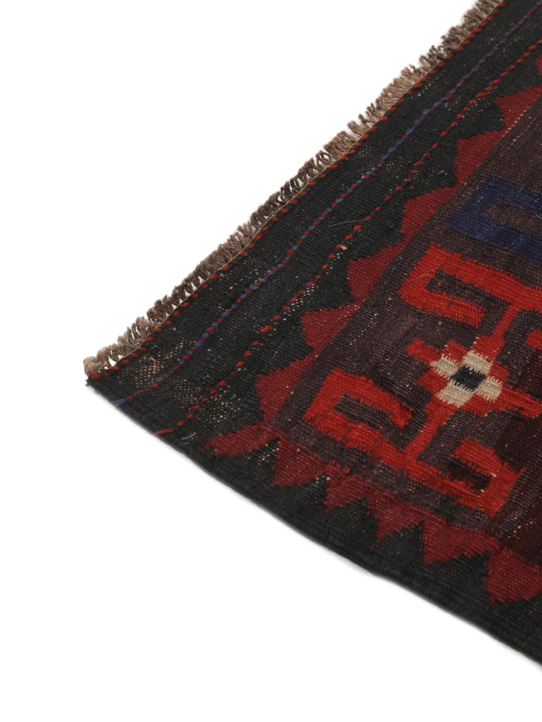 Tapis Kelim afghan tissé à la main avec des motifs géométriques en losange dans les tons rouge, bleu et noir.
