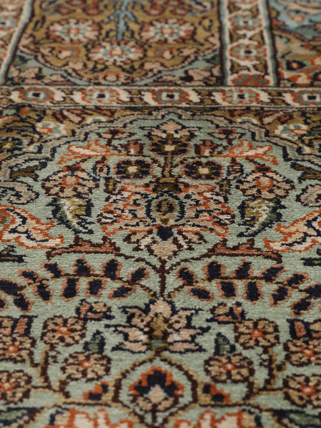 Et rektangulært Kashmir-silketæppe fra Indien med et flerfarvet blomsterdesign.
