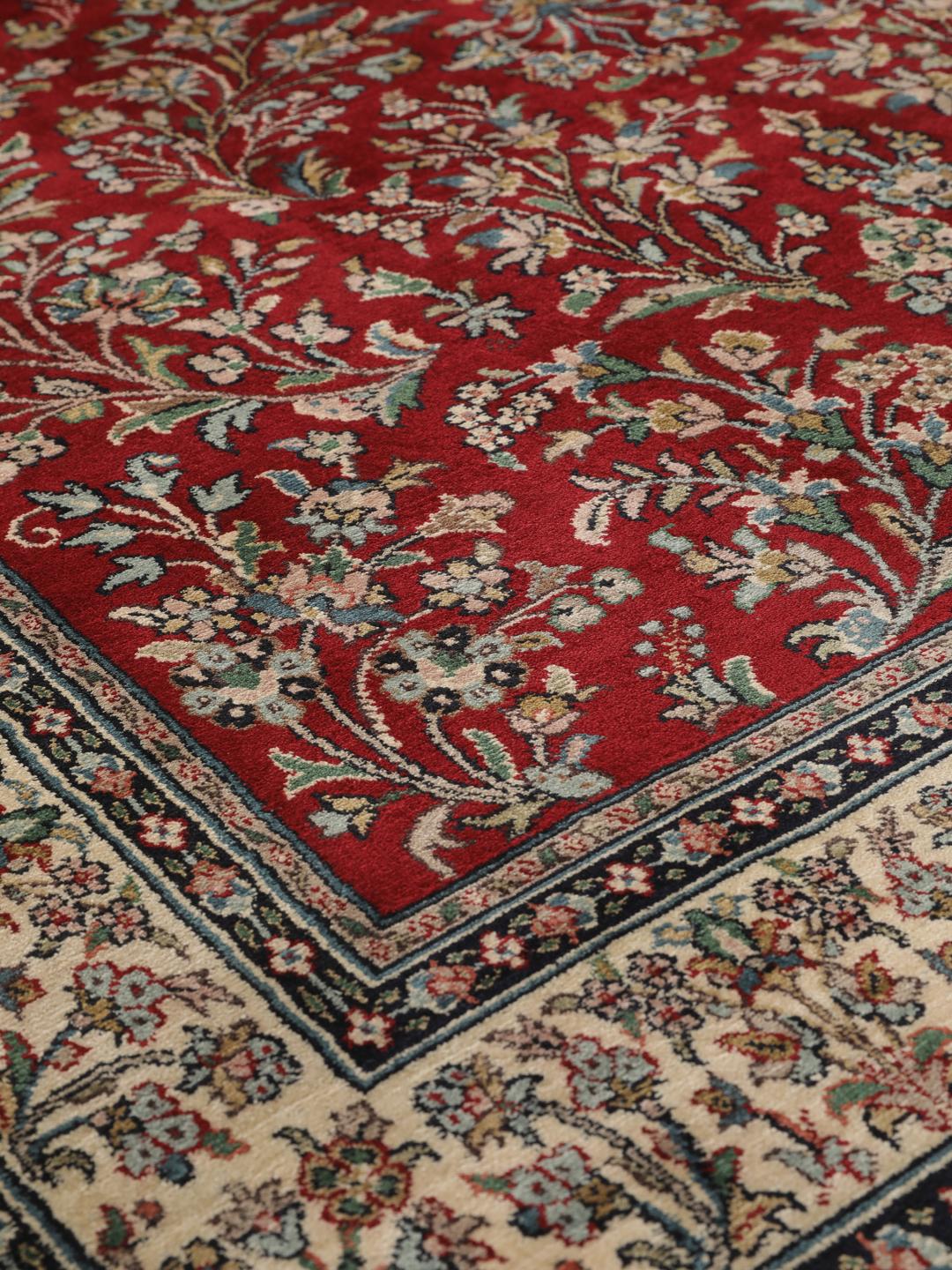 Et håndknyttet Kashmir silketæppe fra Indien med et rødt felt og et indviklet blomstermedaljonmønster.
