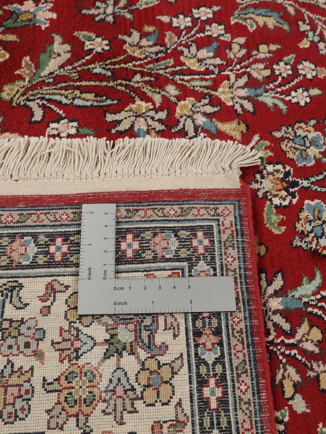 Et håndknyttet Kashmir silketæppe fra Indien med et rødt felt og et indviklet blomstermedaljonmønster.