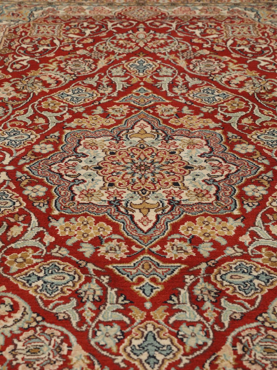 Hand-knotted Kashmir silk rug from India with a vibrant red field and intricate floral motifs.