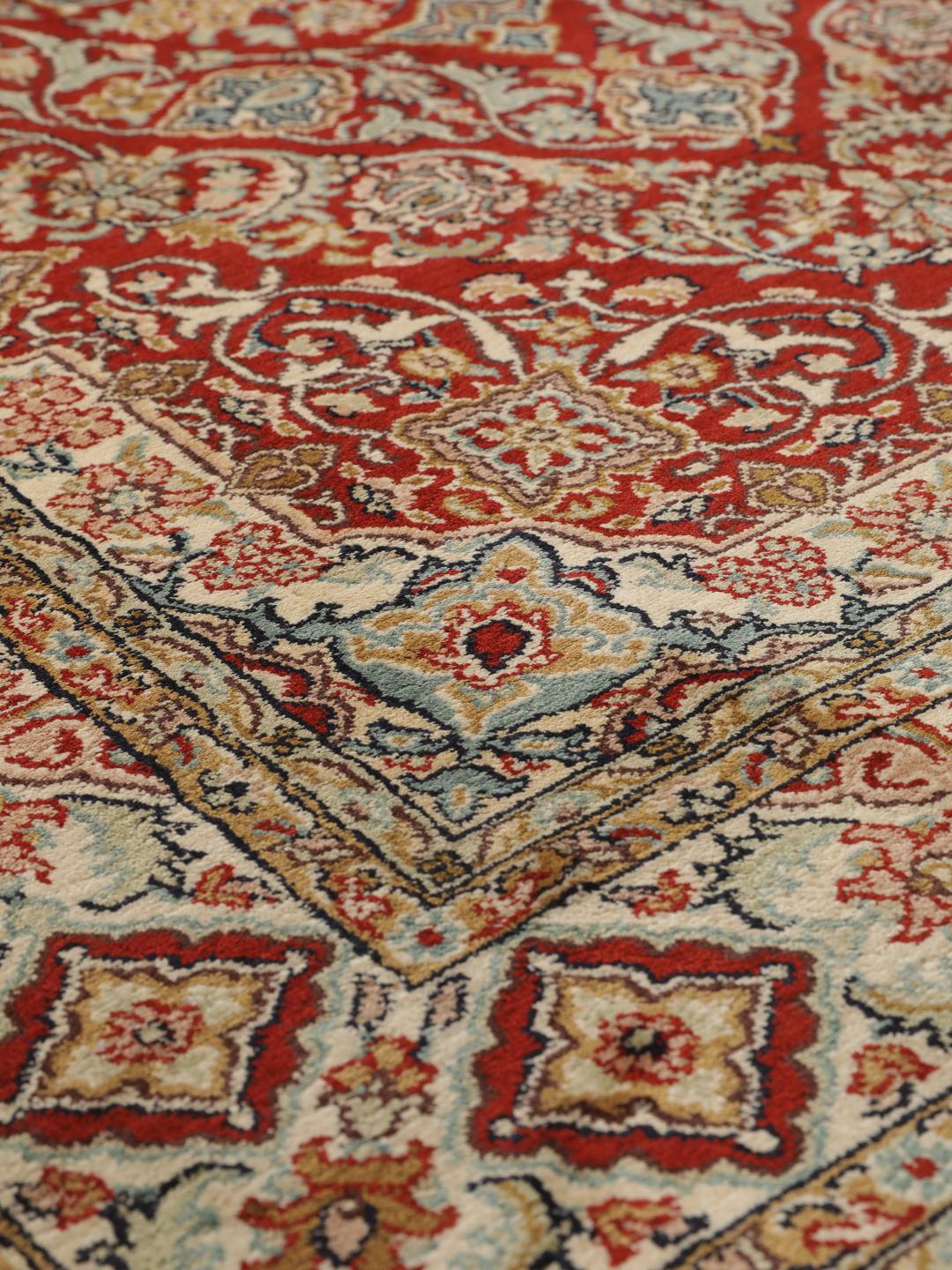 Hand-knotted Kashmir silk rug from India with a vibrant red field and intricate floral motifs.