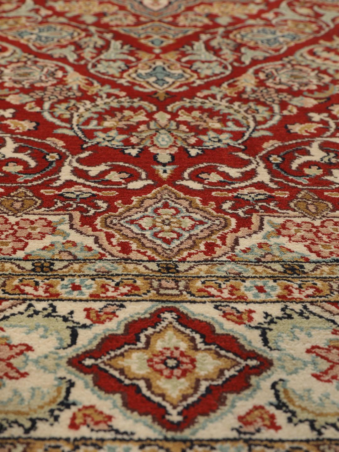 Hand-knotted Kashmir silk rug from India with a vibrant red field and intricate floral motifs.