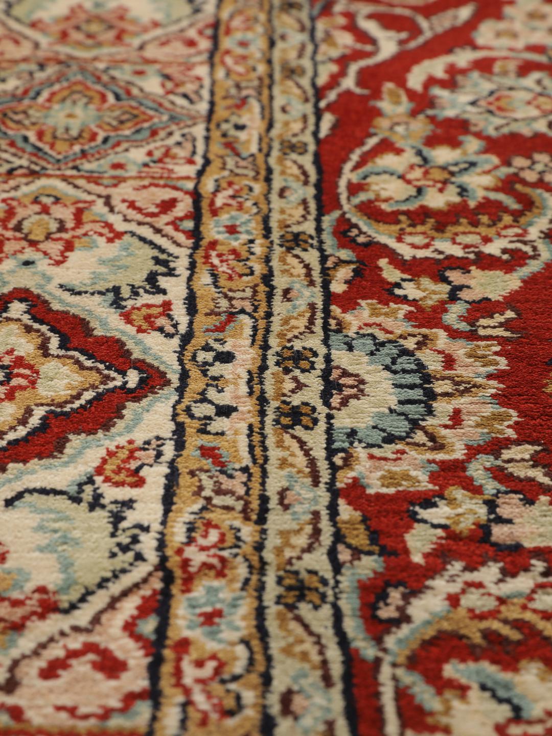Hand-knotted Kashmir silk rug from India with a vibrant red field and intricate floral motifs.